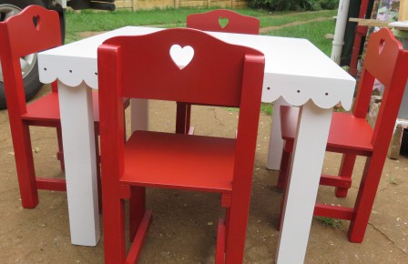Pretty white anglaise table with red chairs